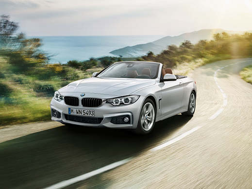 Silver BMW driving on the road.